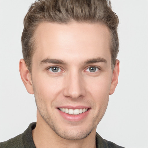 Joyful white young-adult male with short  brown hair and grey eyes