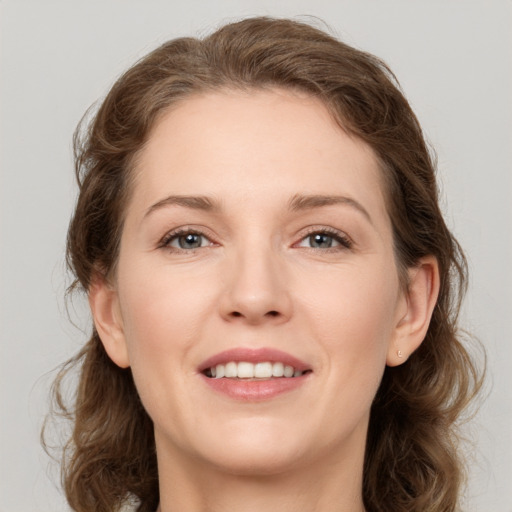 Joyful white young-adult female with medium  brown hair and grey eyes