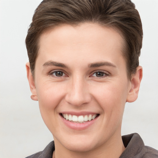 Joyful white young-adult female with short  brown hair and grey eyes