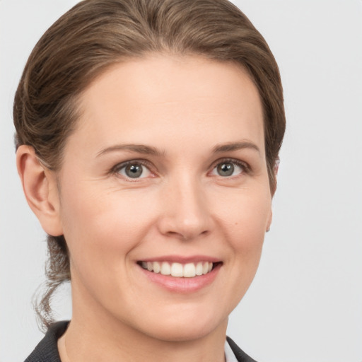 Joyful white young-adult female with medium  brown hair and grey eyes