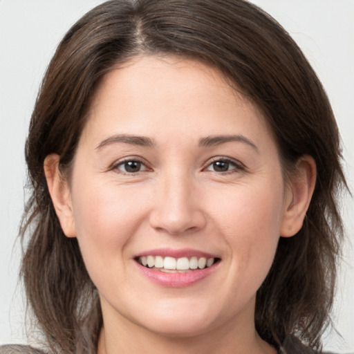 Joyful white young-adult female with medium  brown hair and brown eyes