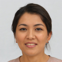 Joyful latino young-adult female with medium  brown hair and brown eyes