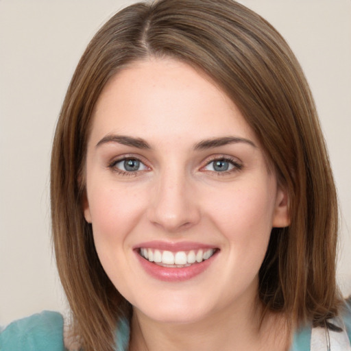 Joyful white young-adult female with medium  brown hair and green eyes