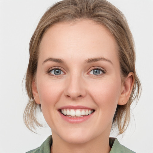 Joyful white young-adult female with medium  brown hair and blue eyes