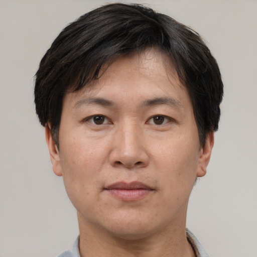 Joyful asian adult male with short  brown hair and brown eyes