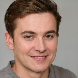 Joyful white young-adult male with short  brown hair and grey eyes