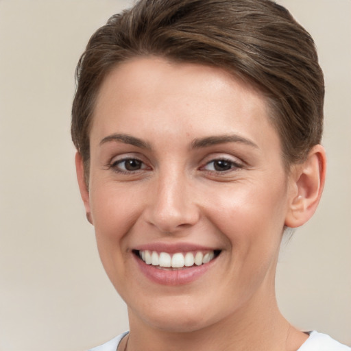 Joyful white young-adult female with short  brown hair and grey eyes