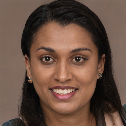 Joyful black young-adult female with long  brown hair and brown eyes