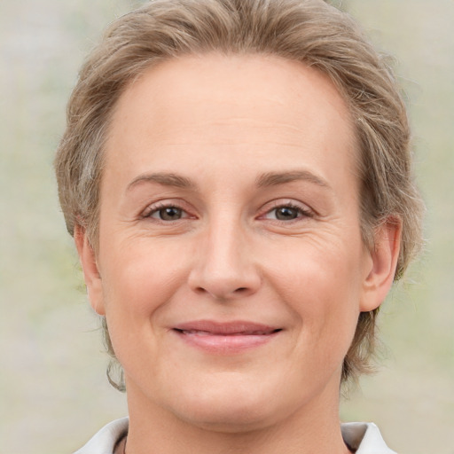 Joyful white adult female with medium  brown hair and grey eyes