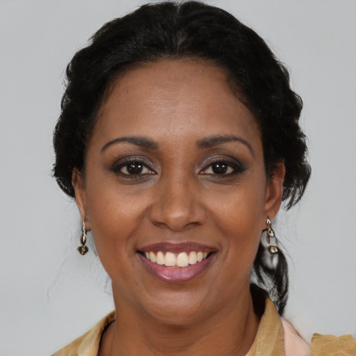 Joyful black adult female with medium  brown hair and brown eyes