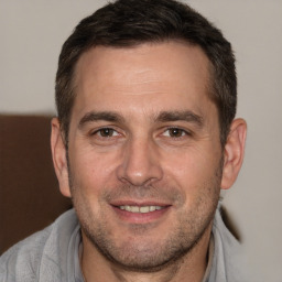 Joyful white adult male with short  brown hair and brown eyes