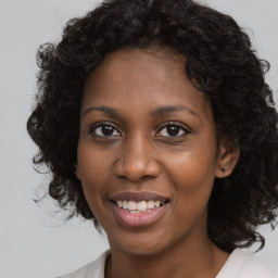 Joyful black young-adult female with medium  brown hair and brown eyes