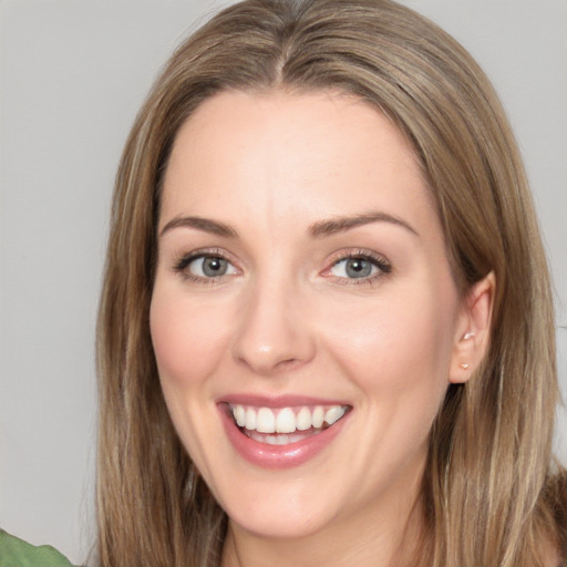 Joyful white young-adult female with long  brown hair and green eyes