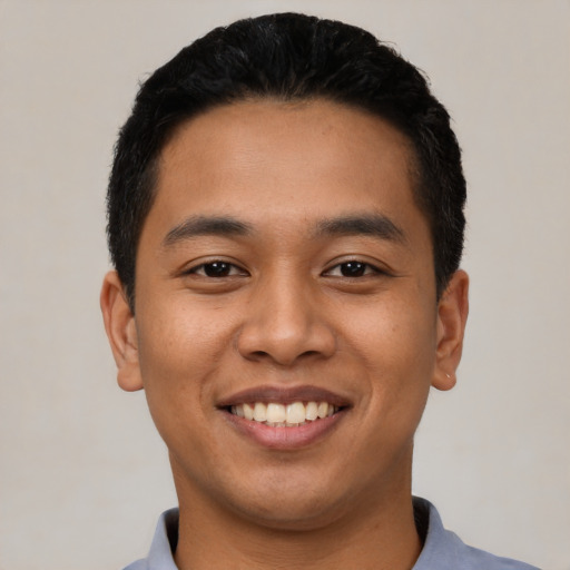 Joyful latino young-adult male with short  black hair and brown eyes
