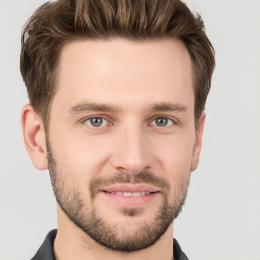 Joyful white young-adult male with short  brown hair and grey eyes