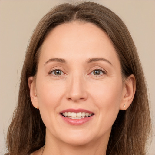 Joyful white adult female with long  brown hair and grey eyes