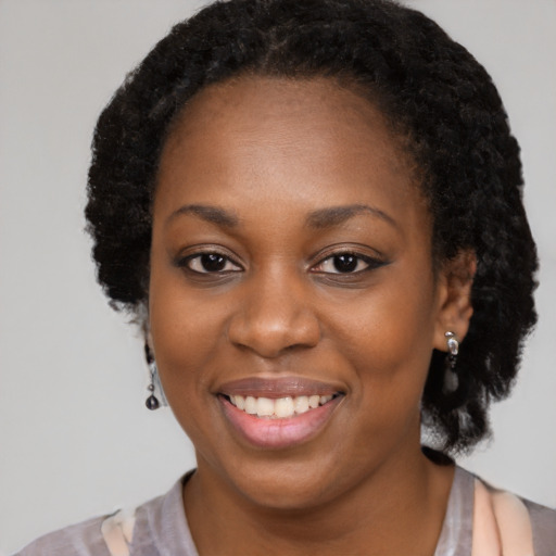 Joyful black young-adult female with long  brown hair and brown eyes