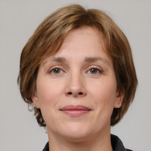 Joyful white adult female with medium  brown hair and grey eyes