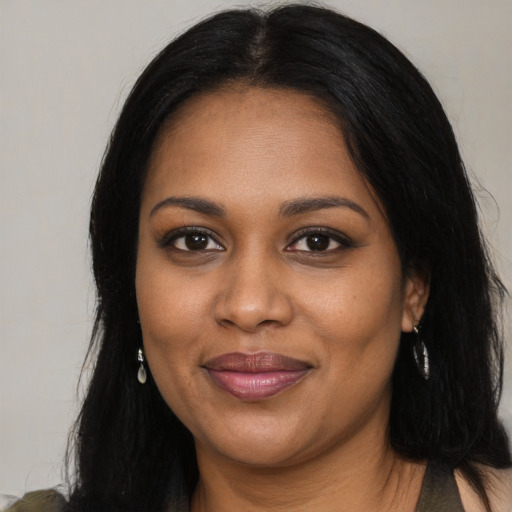 Joyful black young-adult female with long  black hair and brown eyes