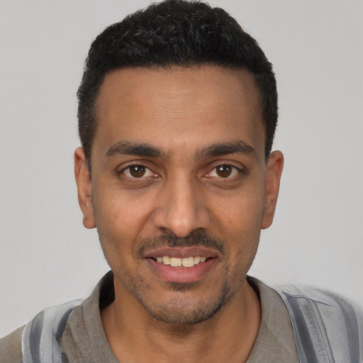 Joyful latino young-adult male with short  black hair and brown eyes