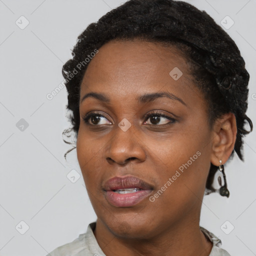 Joyful black young-adult female with short  black hair and brown eyes