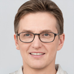 Joyful white adult male with short  brown hair and grey eyes