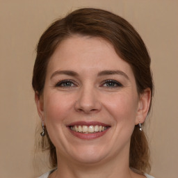 Joyful white young-adult female with medium  brown hair and grey eyes