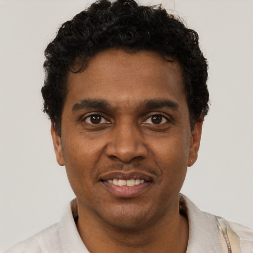 Joyful black young-adult male with short  black hair and brown eyes