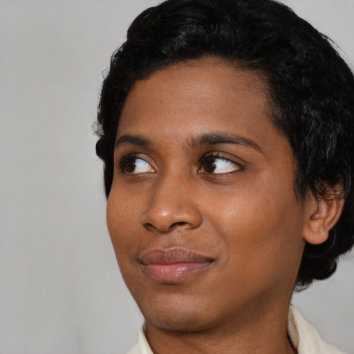 Joyful black young-adult female with short  black hair and brown eyes