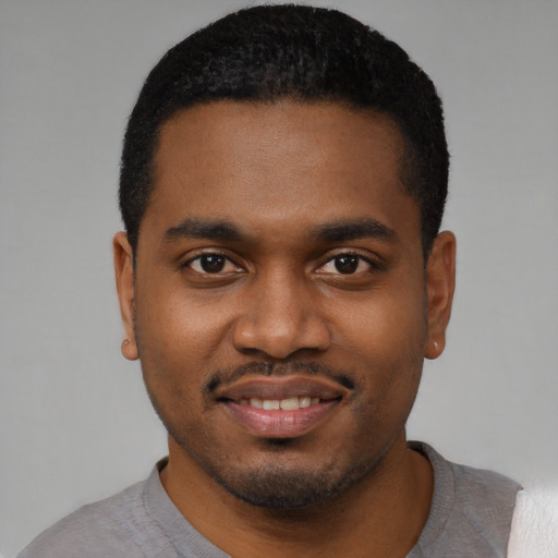 Joyful black young-adult male with short  black hair and brown eyes