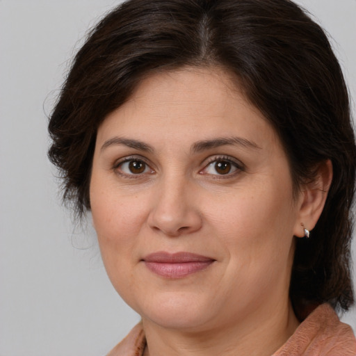 Joyful white adult female with medium  brown hair and brown eyes