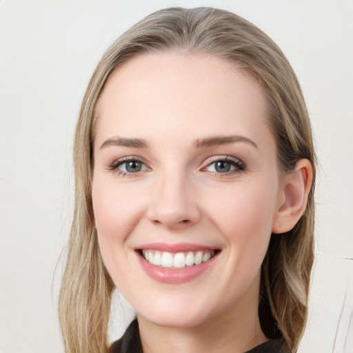 Joyful white young-adult female with long  brown hair and blue eyes