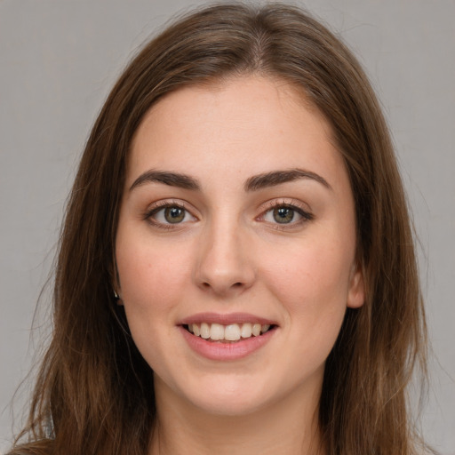 Joyful white young-adult female with long  brown hair and green eyes