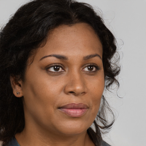 Joyful black young-adult female with long  brown hair and brown eyes
