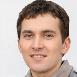 Joyful white young-adult male with short  brown hair and grey eyes