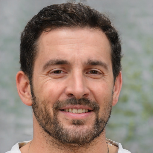 Joyful white adult male with short  brown hair and brown eyes