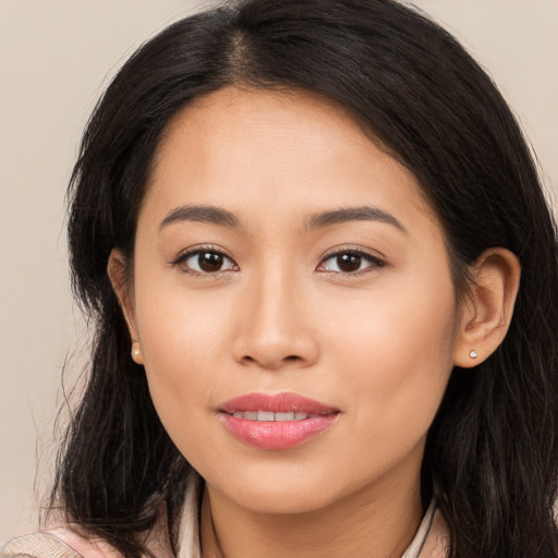 Joyful latino young-adult female with long  brown hair and brown eyes