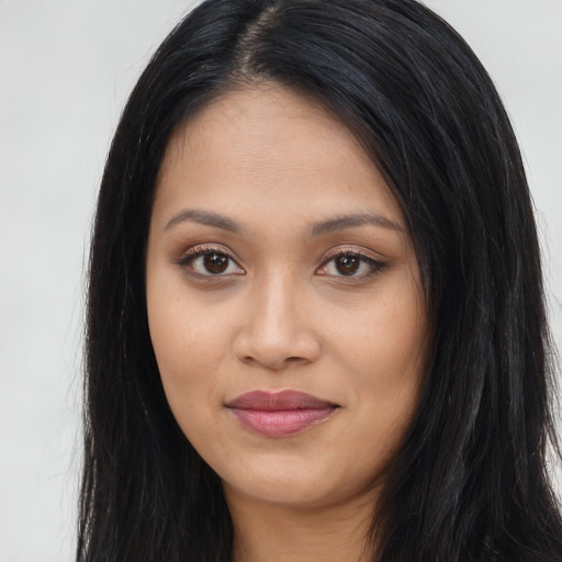 Joyful latino young-adult female with long  black hair and brown eyes
