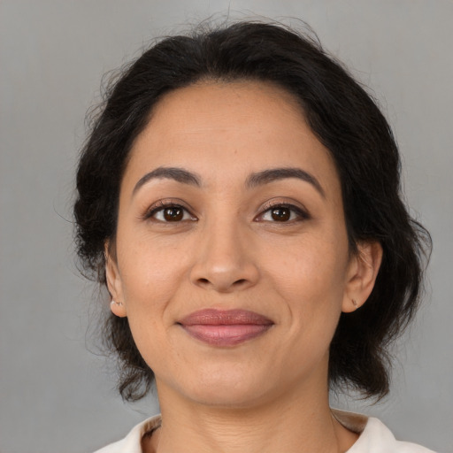 Joyful latino adult female with medium  brown hair and brown eyes