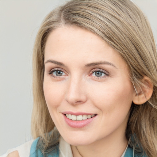 Joyful white young-adult female with long  brown hair and blue eyes