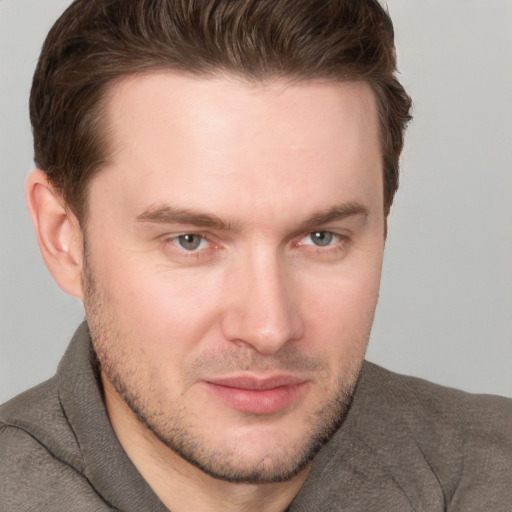 Joyful white young-adult male with short  brown hair and grey eyes