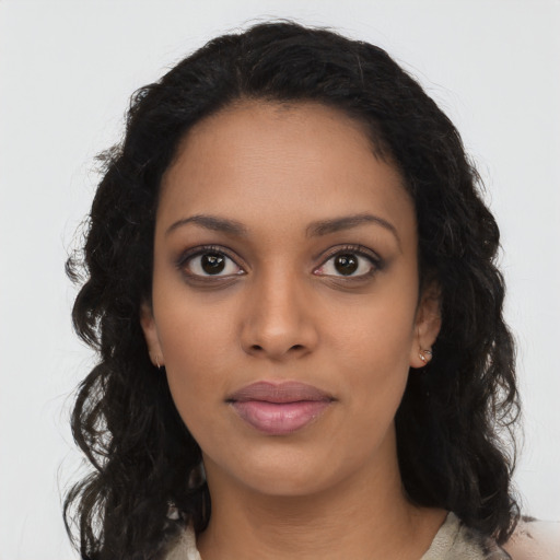 Joyful black young-adult female with long  brown hair and brown eyes
