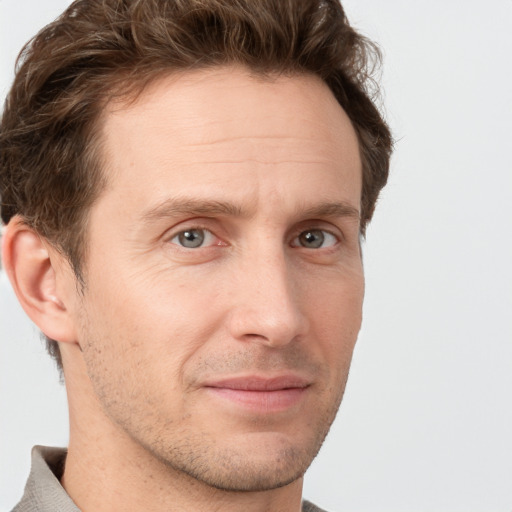 Joyful white adult male with short  brown hair and grey eyes