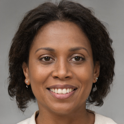 Joyful black adult female with medium  brown hair and brown eyes