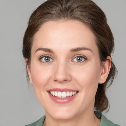 Joyful white young-adult female with medium  brown hair and green eyes