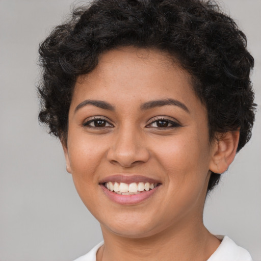 Joyful latino young-adult female with short  brown hair and brown eyes