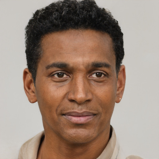 Joyful black adult male with short  black hair and brown eyes