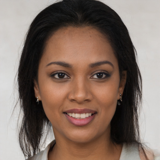 Joyful black young-adult female with long  brown hair and brown eyes