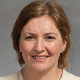 Joyful white adult female with medium  brown hair and blue eyes