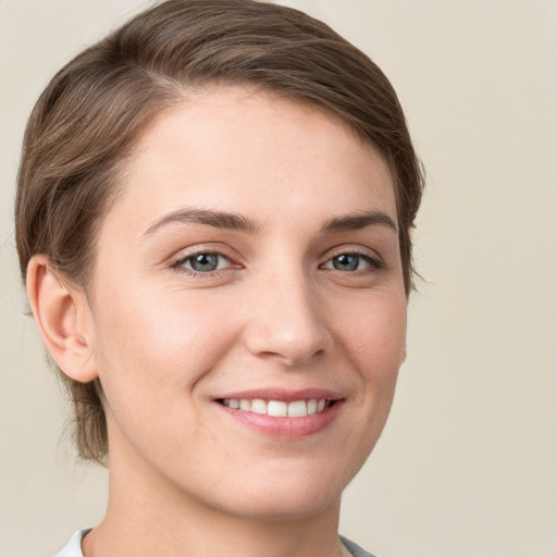 Joyful white young-adult female with short  brown hair and grey eyes